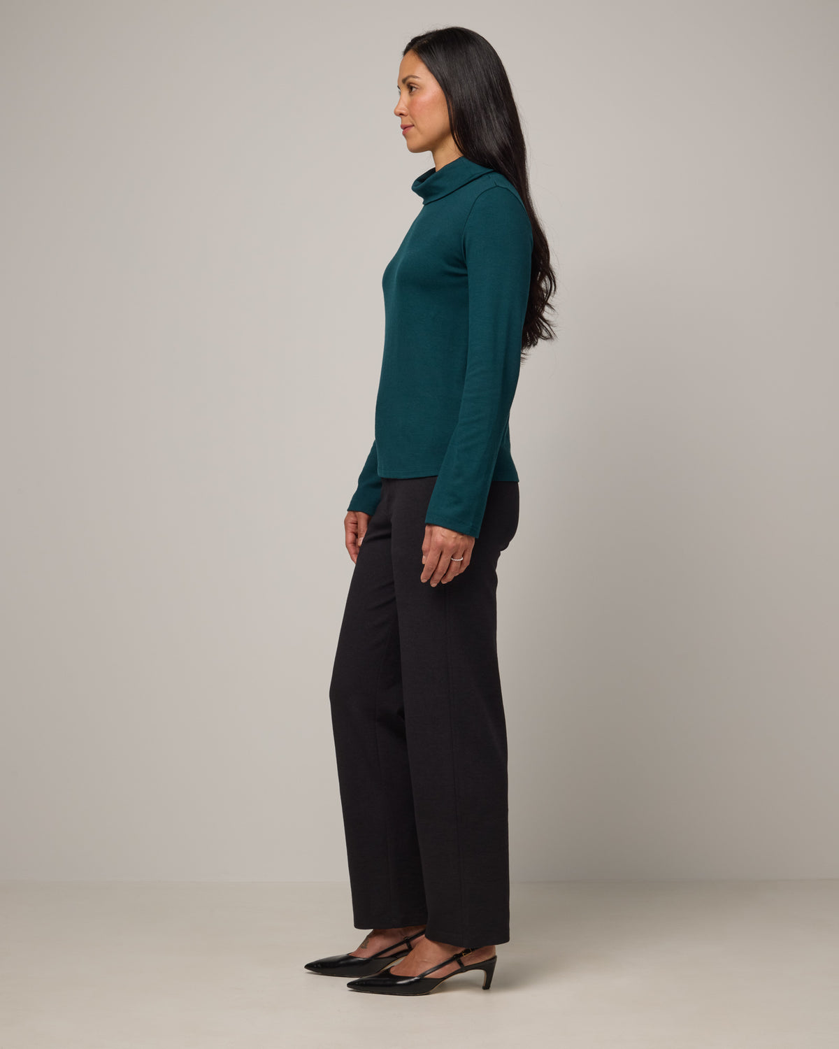 Model wearing Rylie Heavyweight Turtleneck Top in Pine, a dark green color. Rylie Heavyweight Turtleneck Top is a merino wool long sleeve, relaxed fit turtleneck available in sizes XS-3X.
