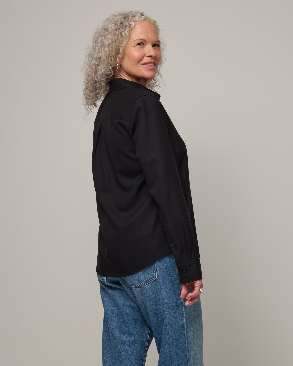 Model wearing Tiffany Button-Front Shirt in Black. Tiffany Button-Front Shirt is a merino wool long sleeve collared shirt available in sizes XS-XXL.