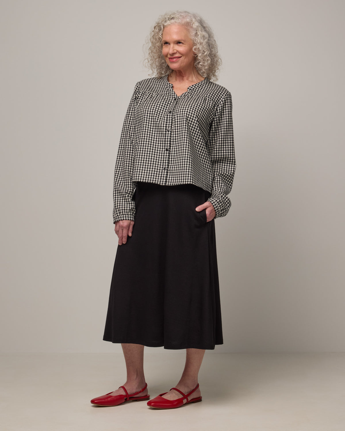 Model wearing Raquel Brushed Twill Top in Black & White Gingham. Raquel Brushed Twill Top is a 100% merino wool long sleeve, split collar button-front shirt available in sizes XS-XXL.