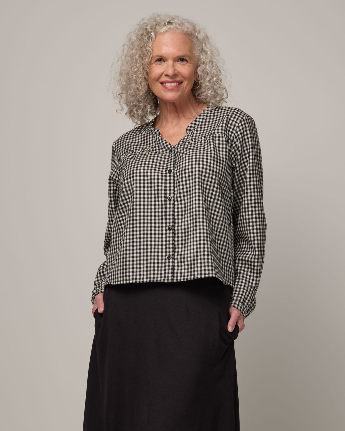 Model wearing Raquel Brushed Twill Top in Black & White Gingham. Raquel Brushed Twill Top is a 100% merino wool long sleeve, split collar button-front shirt available in sizes XS-XXL.