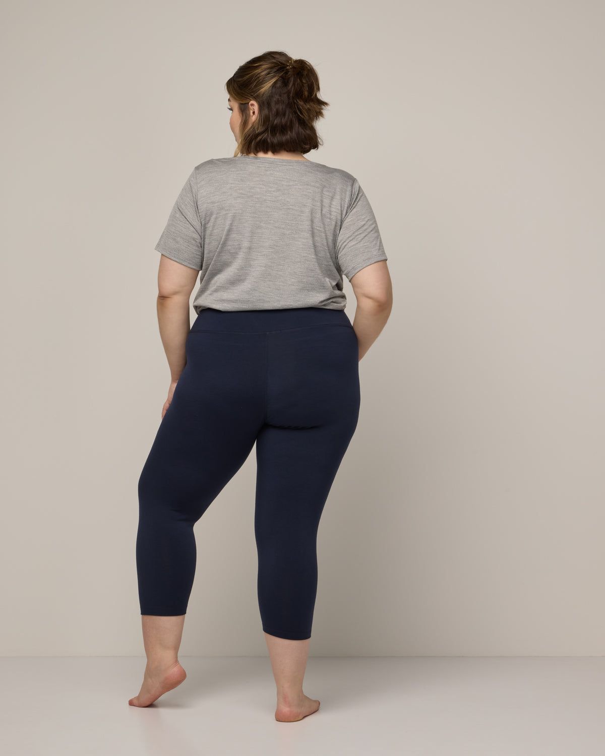 Model wearing Summit Crop Legging in Navy. Summit Crop Legging is a merino wool legging available in sizes XS-3X.
