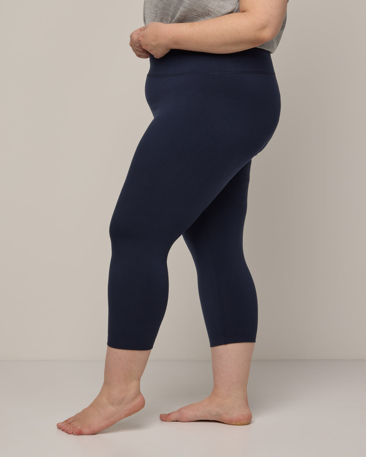 Model wearing Summit Crop Legging in Navy. Summit Crop Legging is a merino wool legging available in sizes XS-3X.